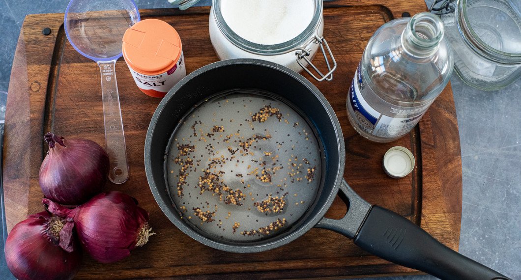 För att pickla rödlök behöver du rödlök, salt, socker, ättika och senapsfrön (valfritt). 