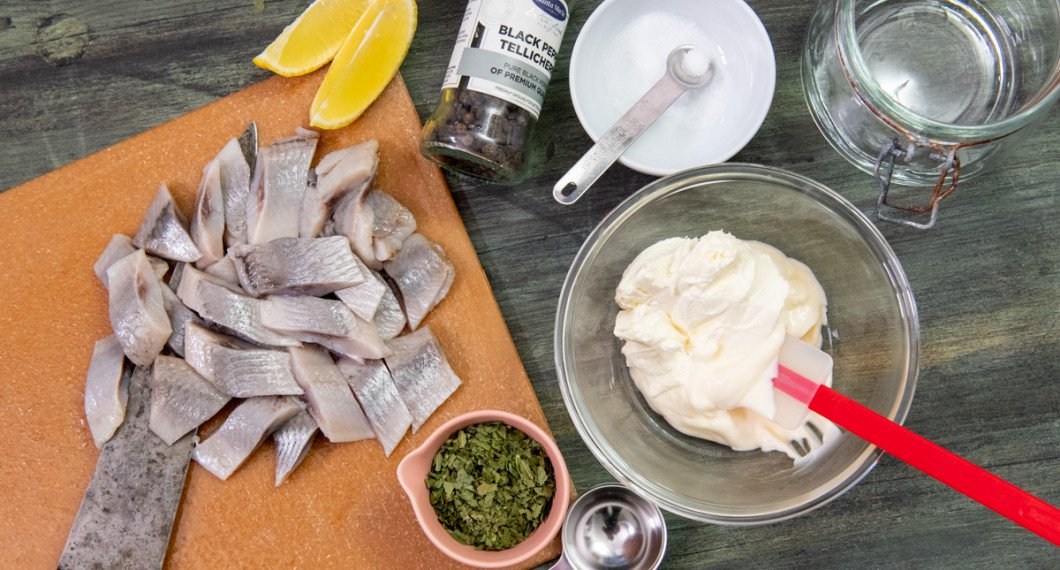 Inläggninssill, citron, svartpeppar, salt, crème fraiche, majonnäs och torkad ramslök. 