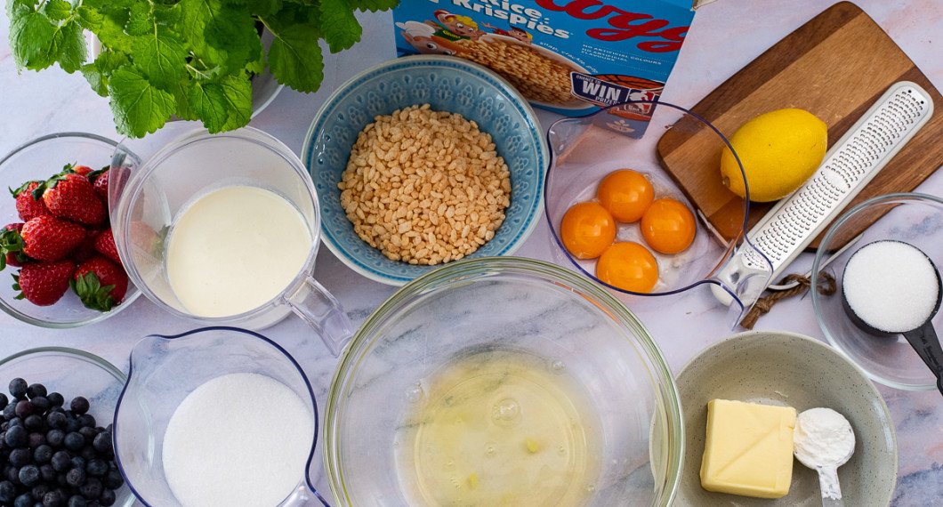 Till tårtan behöver du jordgubbar, blåbär, citronmeliss, socker, grädde, äggvitor, rice krispies, äggulor, citron, smör och maizena. 