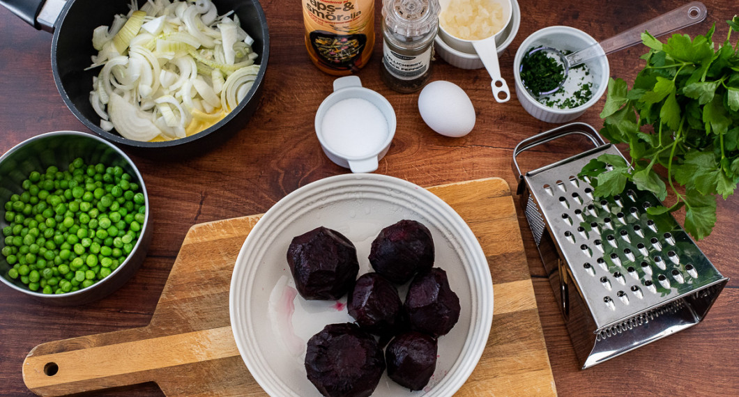 Ingredienser till rödbetsbiffarna: Kokta rödbetor, salt, ägg, matfett, svartpeppar, lök, persilja samt gröna ärtor och strimlad lök med smör att ha som tillbehör. 