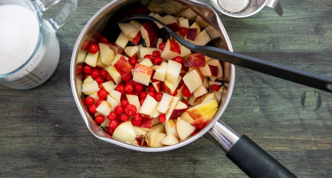 Lägg rönnbär och tärnade äpplen i en kastrull. 