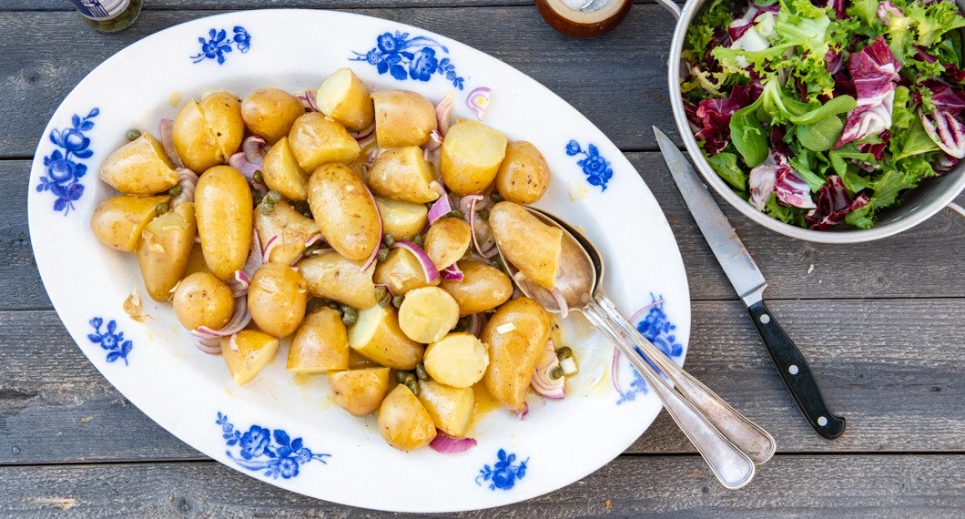 Potatisen blandad med Dijon- och senapsdressingen på fat. 
