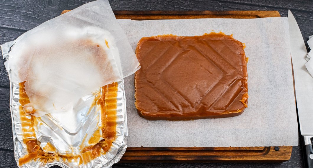 Skär längs kanten och stjälp upp kolan upp och ner på ett bakplåtspapper. Dra bort bakplåtspappret. 