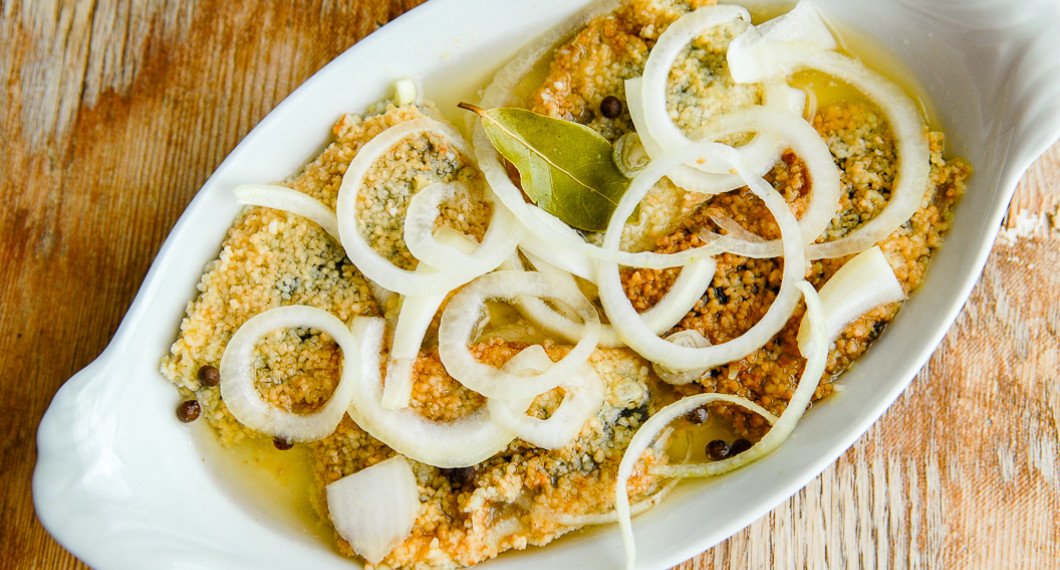 Stekt inlagd strömming på fat med lök och lagerblad