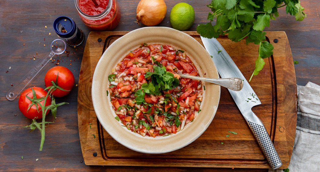 Ingredienser till tomatsalsan: färska tomater, chili som chiliflakes, krossade tomater, gul lök, lime och färsk koriander. 