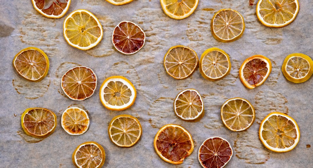 Citrus som citron och lime i tunna skivor som får torka på bakplåtspapper. 