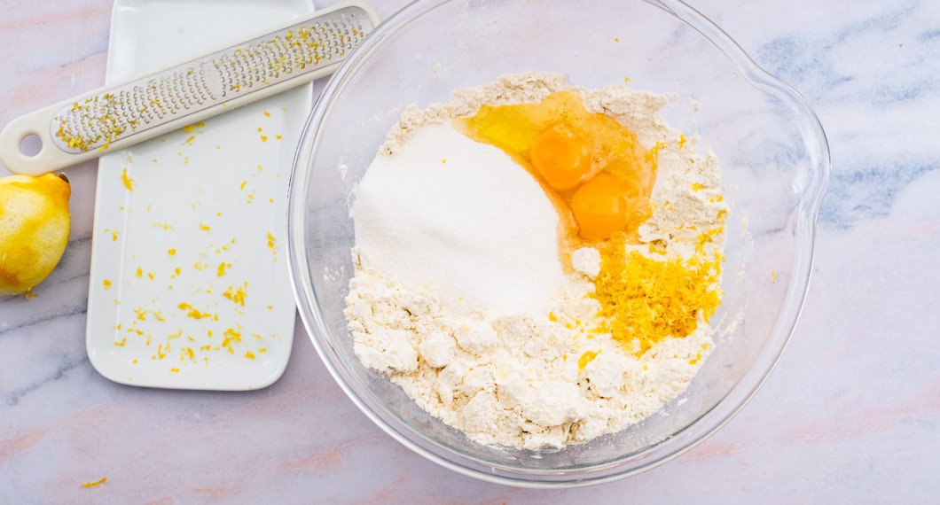 Tärna kallt smör och lägg i en bunke med vetemjöl, ägg, socker samt rivet citronskal. 