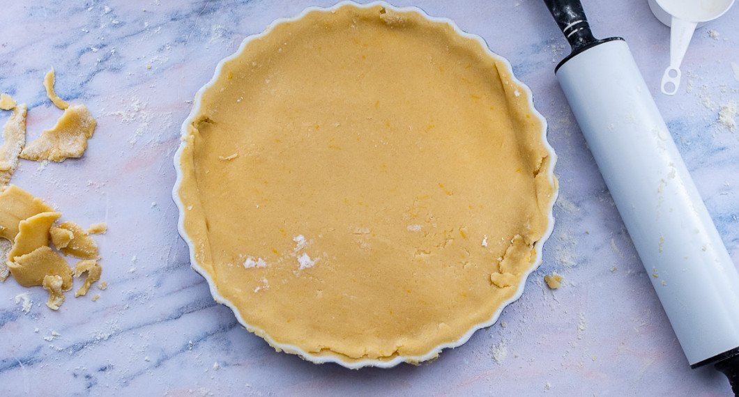 Rulla upp locket på kaveln och lägg det över fyllningen. Skär bort kanter.