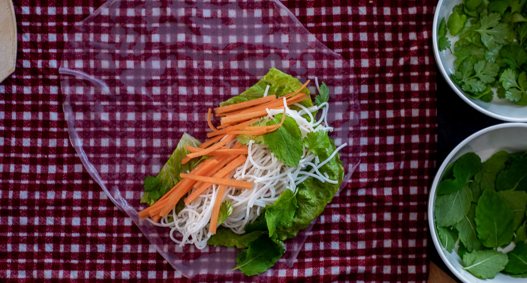 Lägg ett blad sallad, en hög risnudlar, strimlad morot och färsk koriander samt mynta i nedre delen på rispappret. 