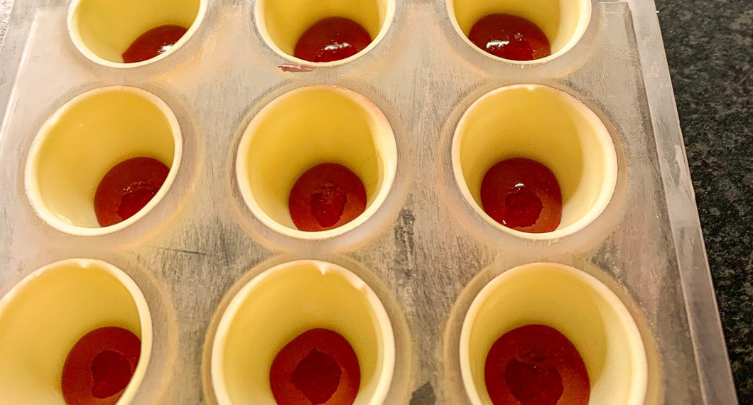 Skal med vit choklad gjuts först i pralinfacken och får stelna. 