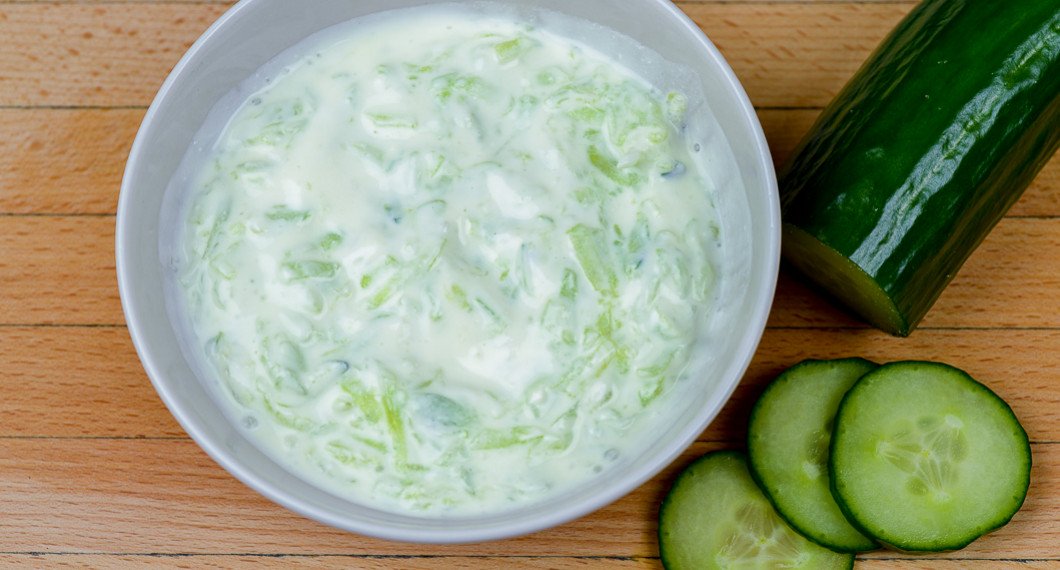 Yoghurtsås eller tzatziki utan vitlök med riven gurka i skål. 