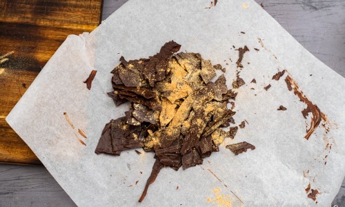 Bryt chokladen i grova bitar på ca 4-5 cm samt strö över lite guldpulver att använda som dekor över tårtan. 