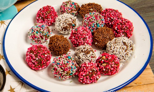 Chokladbollar i olika varianter med kokosflingor, pärlsocker eller strössel på tallrik. 