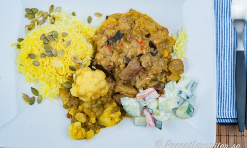Currygryta med biff serverad på tallrik med tillbehör