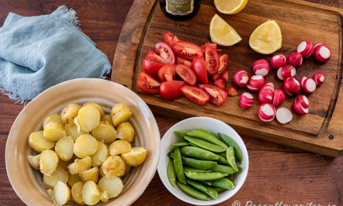 Kokt färskpotatis, salladsärtor, tomatklyftor, skivade rädisor, citron och olivolja till salladen. 