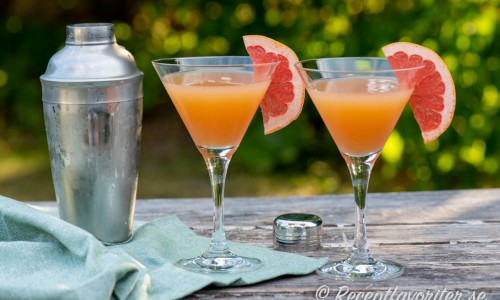 Grapefruktcocktail i glas garnerad med skivad grapefrukt. 