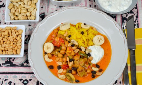 Currygrytan är god med kokt ris, matyoghurtsås, jordnötter, cashewnötter, banan och russin. 