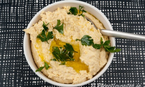 Hummus i skål med olivolja och persilja