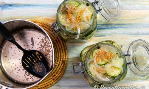 Packa gurka med kryddorna i glasburkar och fyll på med varm lag. Sätt på lock. 