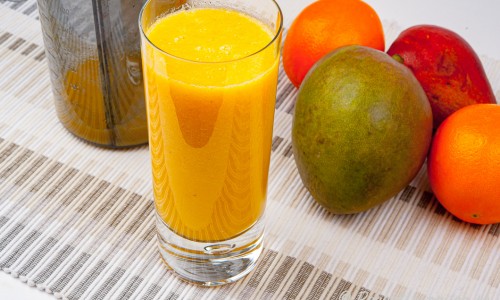 Ett glas juice med apelsin, mango och päron. 