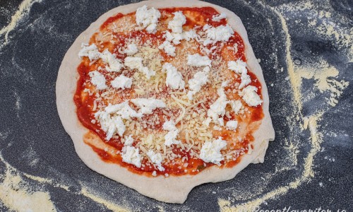 Bred först ut pizzasås. Sedan riven mozzarella och grovt delad färsk mozzarella. 