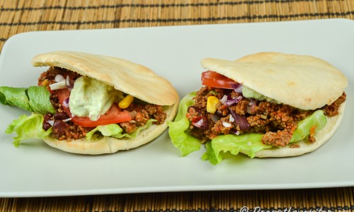 En variant på tacos med köttfärs i pitabröd istället för tortillabröd eller tacoskal - här med fräst köttfärs, guacamole, majs, rödlök, sallad, tomat och bönor. 