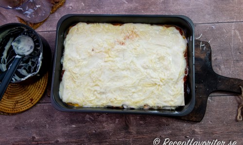 Toppa lasagnen med resten av Bechamelsåsen samt riven mozzarella och resten av parmesanosten. 