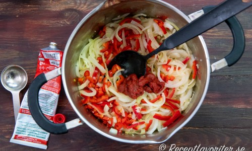 Tillsätt strimlad paprika, vitlök och tomatpuré. Fräs några minuter till. 