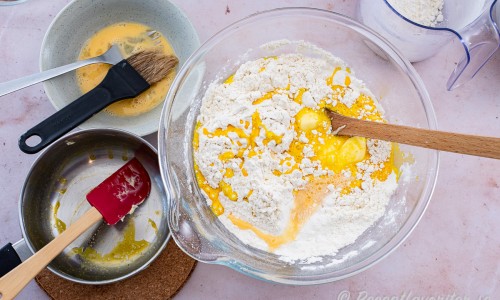 Tillsätt mjölkblandningen samt nästan allt ägg till bunken med mjöl. Spara lite ägg till pensling. 