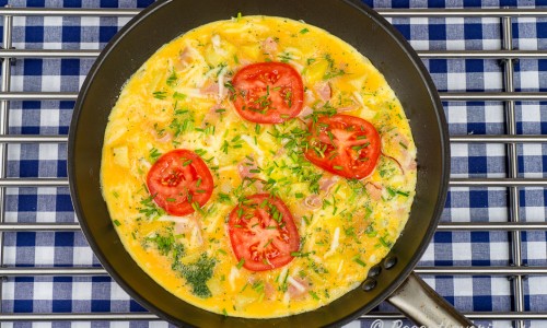 Omelett med skinka och tomat i panna