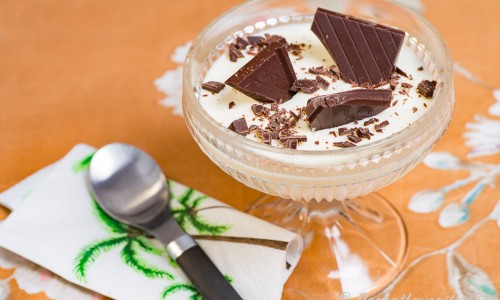Pannacotta med vit chokladlikör i coupeglas till dessert garnerad med fin mörk choklad