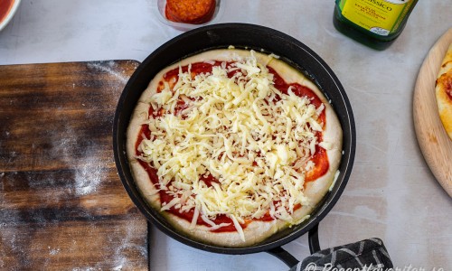 Bred ut pizzasås och fördela över riven ost. 