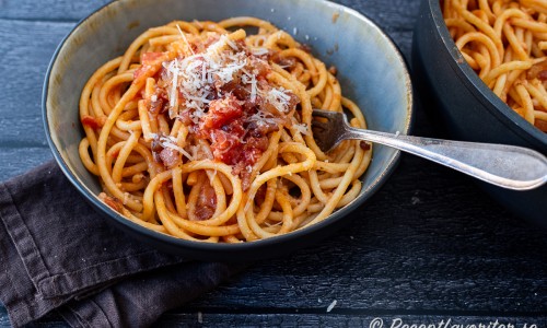 Pasta Amatriciana med guanciale fläsk i tomatsås toppad med pecorino romano. 