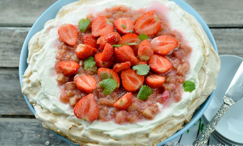 En marängtårta med grädde och smält rabarber - strimlad rabarber kokt med socker - samt färska jordgubbar. 