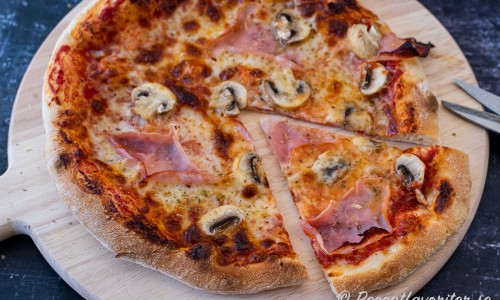 Du kan servera pizzan på rund skärbräda med sax att klippa slicar samt äta med händerna. Eller tallrik med kniv och gaffel. 