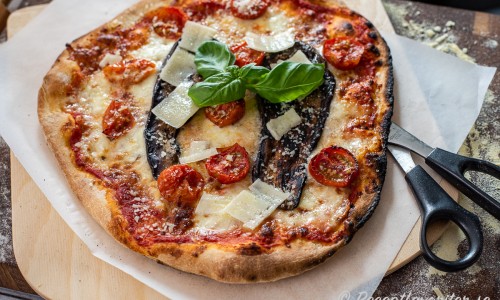 Pizzan kan du servera på bakplåtspapper på en skärbräda eller tallrik med sax eller kniv och gaffel. 