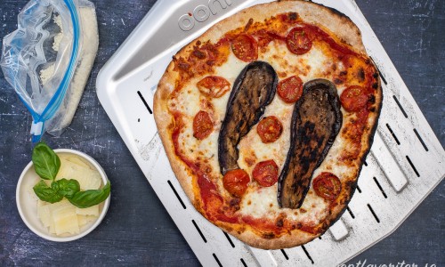 När pizzan är gräddad lägger du på rostade tomater, hyvlad pecorino, riven parmesan samt färsk basilika. 