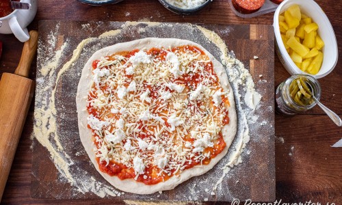 Bred först ut pizzasås. Sedan riven mozzarella och grovt delad färsk mozzarella. 