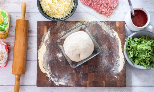Förbered deg, pizzasås, riven mozzarella och Västerbottenost (ej med på bilden), tryffelsalami samt rucola.