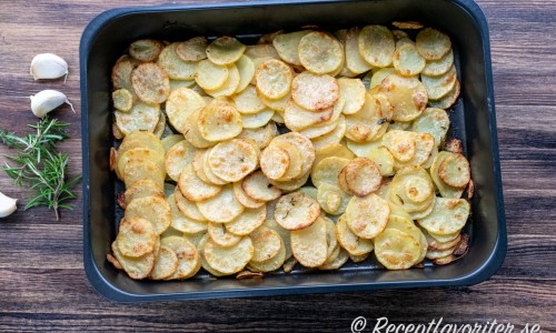 Råstekt skivad potatis med timjan, rosmarin och vitlök i form. 