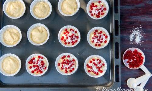 Smeten till muffinsen fylls i muffinsformar på en bakplåt. 