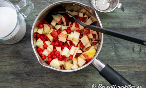 Lägg rönnbär och tärnade äpplen i en kastrull. 