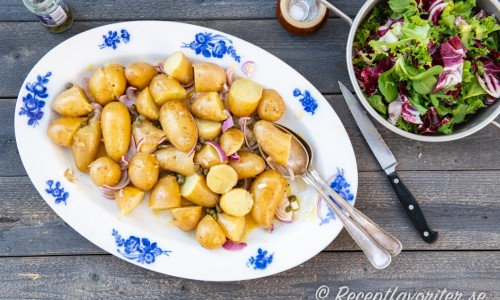 Potatisen blandad med Dijon- och senapsdressingen på fat. 