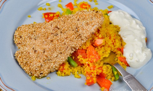 Sesampanerad kycklingfilé med couscous och kall sås på tallrik