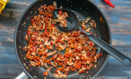 Fräst bacon, soltorkad tomat, chili och vitlök samt olivolja i en panna. 