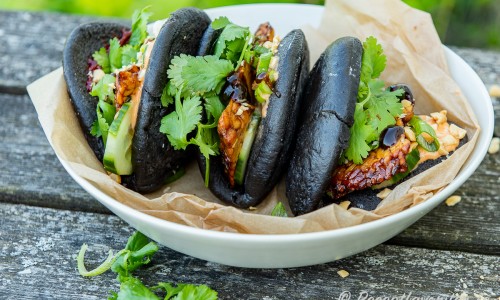Svarta bao bullar fyllda med grillad tempeh, sås, jordnötter och grönt. 