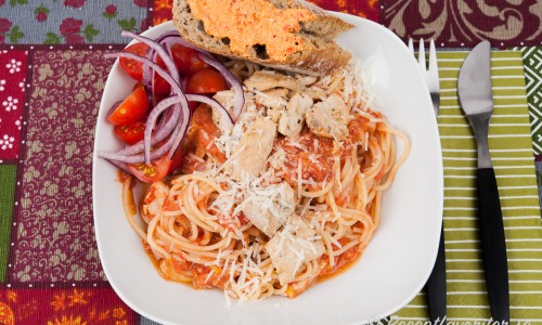 Pasta - här spagetti - med tomatsås, kyckling och riven parmesan. 