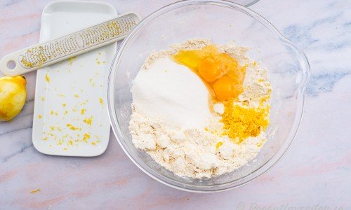 Tärna kallt smör och lägg i en bunke med vetemjöl, ägg, socker samt rivet citronskal. 