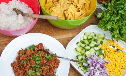 Vegetarisk sojafärs texmex style, gurka, rödlök, majs, kokt ris, färsk koriander, chilisås sriracha och nacho-chips. 