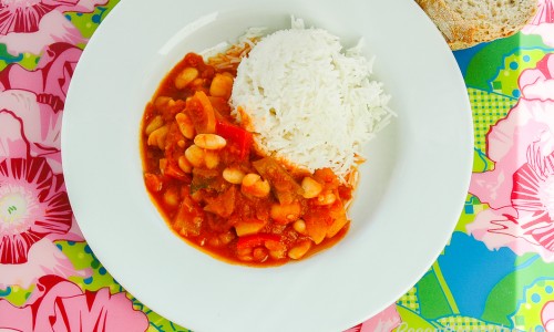 Vegetarisk gryta med vita bönor och paprika serverad med ris i tallrik